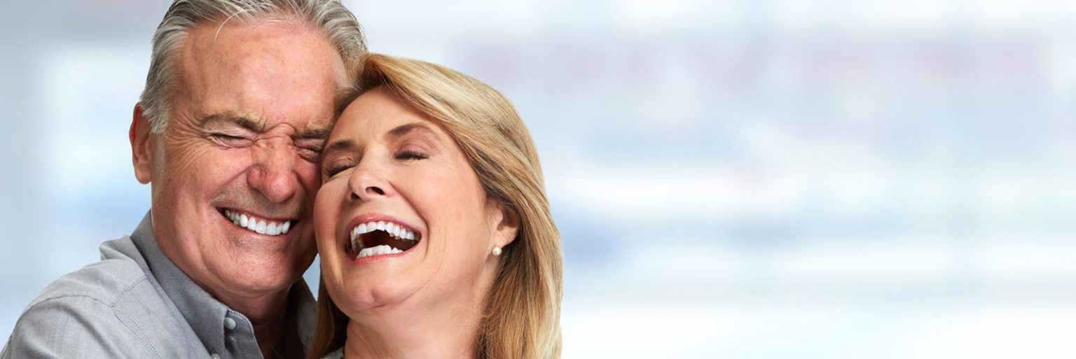 A senior couple laughing together, cheek to cheek